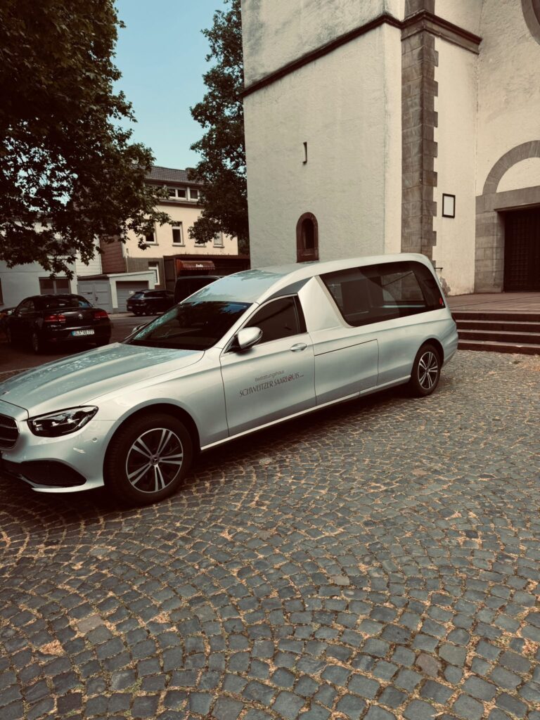 Mercedes E-Klasse Bestattungswagen des Bestattungshauses Schweitzer vor einer Kirche in Saarlouis